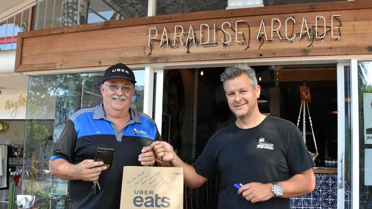 FAST FOOD: Uber Eats delivery driver Rick Bolsterli collected Paradise Arcade's first Uber Eats order from owner Colin Benge. Picture: Caitlin Zerafa