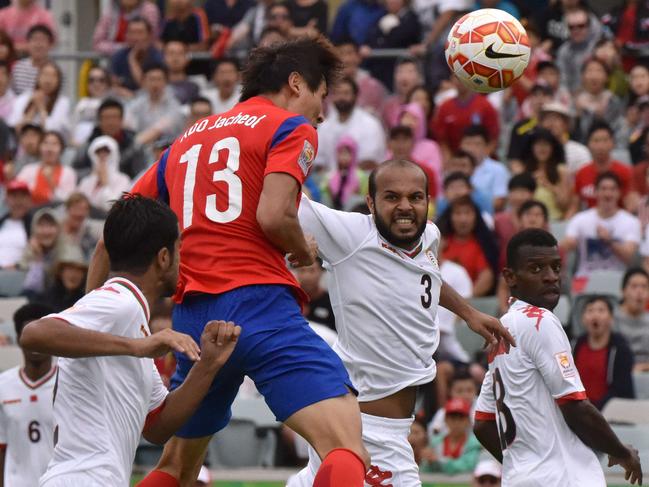 Koo Ja Cheol of South Korea (red) heads for goal during the first round Asian Cup football match between South Korea and Oman in Canberra on January 10, 2015. AFP PHOTO / MARK GRAHAM --- IMAGE RESTRICTED TO EDITORIAL USE - STRICTLY NO COMMERICAL USE --