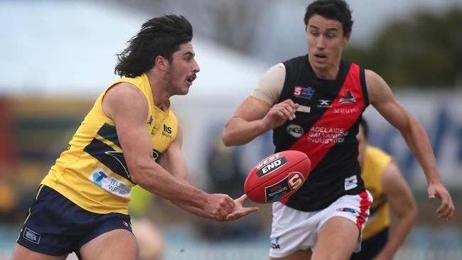 Eagles’ Lachlan Jones handballs in front of West’s Tom Keough. Picture: Dean Martin