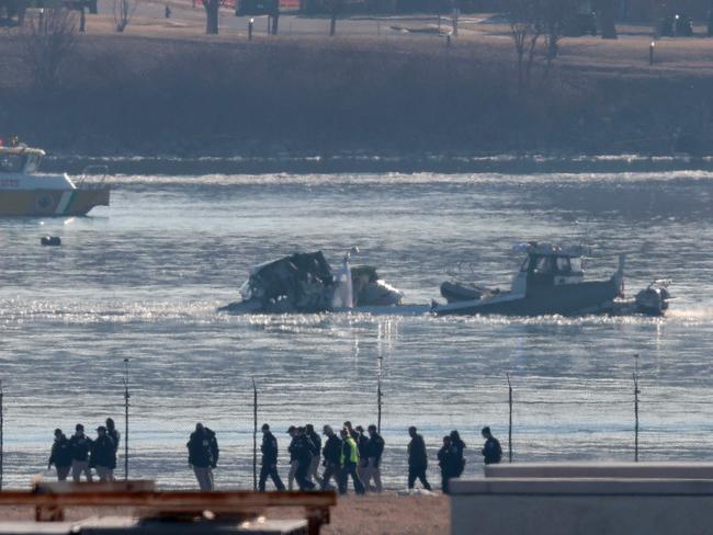 Investigators walk the grounds of the Reagan National Airport as they work near the crash last night of the American Airlines plane on the Potomac River. Picture: Getty Images via AFP