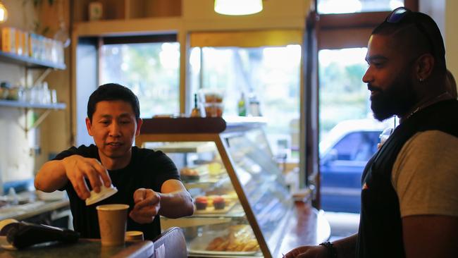 Cafe owner Marc Zheng serves a takeaway coffee at Le Petit Tarte Cafe in Sydney. Picture: AAP.
