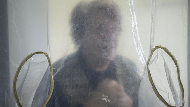 Sara Azar, 88, speaks to her son Nelson visit through a window at Hogar Israelita nursing home in Montevideo, Uruguay. Picture: Getty Images