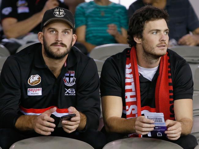 MELBOURNE, AUSTRALIA - APRIL 21:  Injures St Kilda players Josh Bruce and Dylan Roberton sit in the stands during the round five AFL match between the St Kilda Saints and the Greater Western Sydney Giants at Etihad Stadium on April 21, 2018 in Melbourne, Australia.  (Photo by Darrian Traynor/AFL Media/Getty Images)