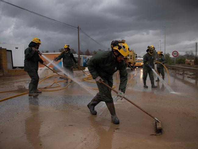 Members of the INFOCA (Andalusia Fire Prevention and Extinction Plan) clean a flooded street in Cartama, near Malaga. Picture: AFP