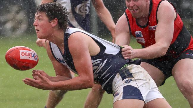 Evan Donoghue fires out a handball for Melton Centrals. Picture: Hamish Blair