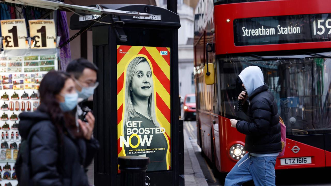 Pedestrians walk past an electronic billboard promoting Britain's National Health Service's (NHS) Covid-19 vaccine booster program. Picture: Tolga Akmen/AFP