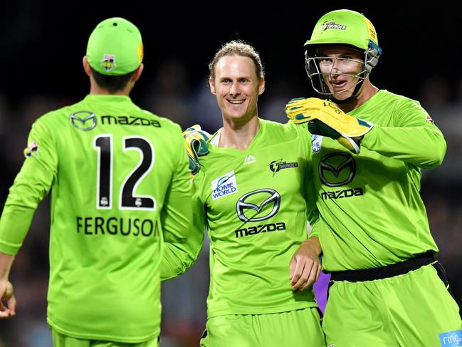 Jono Cook (centre) of the Thunder celebrates with Callum Ferguson (left) and Jay Lenton (right) after getting the wicket of D'Arcy Short of the Hurricanes during the Big Bash League (BBL) eliminator final cricket match between Hobart Hurricanes and Sydney Thunder at Blundstone Arena in Hobart, Thursday, January 30, 2020. (AAP Image/Darren England) NO ARCHIVING, EDITORIAL USE ONLY