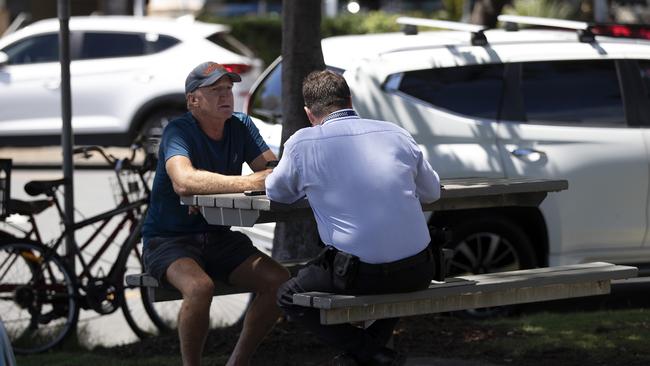 A Detective speaks with a man believed to be a witness. Picture: Nigel Hallett