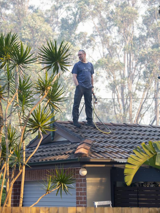 A resident seeks to protect a property. Picture: NewsWire / Jeremy Piper