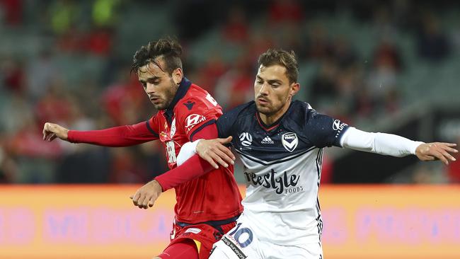 Now teammates. Adelaide United’s Nikola Mileusnic links arms with his new teammate, former Melbourne Victory attacker James Troisi. Picture Sarah Reed