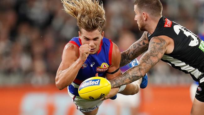 MELBOURNE, AUSTRALIA - MARCH 19: Bailey Smith of the Bulldogs is tackled by Jeremy Howe of the Magpies during the 2021 AFL Round 01 match between the Collingwood Magpies and the Western Bulldogs at the Melbourne Cricket Ground on March 19, 2021 in Melbourne, Australia. (Photo by Michael Willson/AFL Photos via Getty Images)