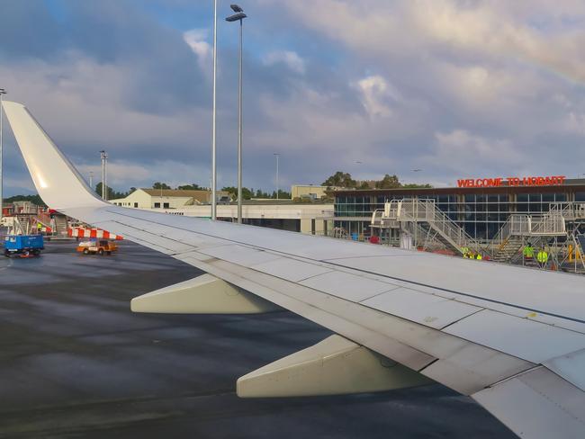 Airplane wing with rainbow. Hobart Airport building is in the background. Hobart, Tasmania, Australia. June 30, 2019. Yoav Daniel Bar-Ness. For TasWeekend.