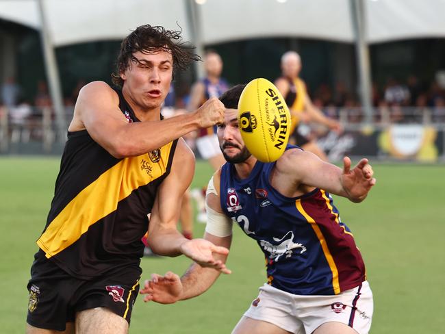 Tigers' Billy Welch handballs away from Lions captain Sean Connolly in the AFL Cairns premiership men's preliminary final match between the Cairns City Lions and the North Cairns Tigers, held at Cazalys Stadium, Westcourt. Picture: Brendan Radke