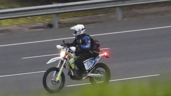 Police on off-road bikes scour the area for clues. Picture: David Crosling