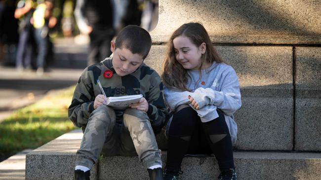 Cash, 10, and Billie Rose Alway, 8, draw Melbourne’s march. Picture: Tony Gough