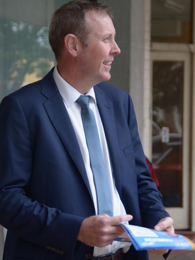 Groom MP Garth Hamilton hands out how-to-vote cards outside the federal election early voting centre in the Toowoomba CBD.