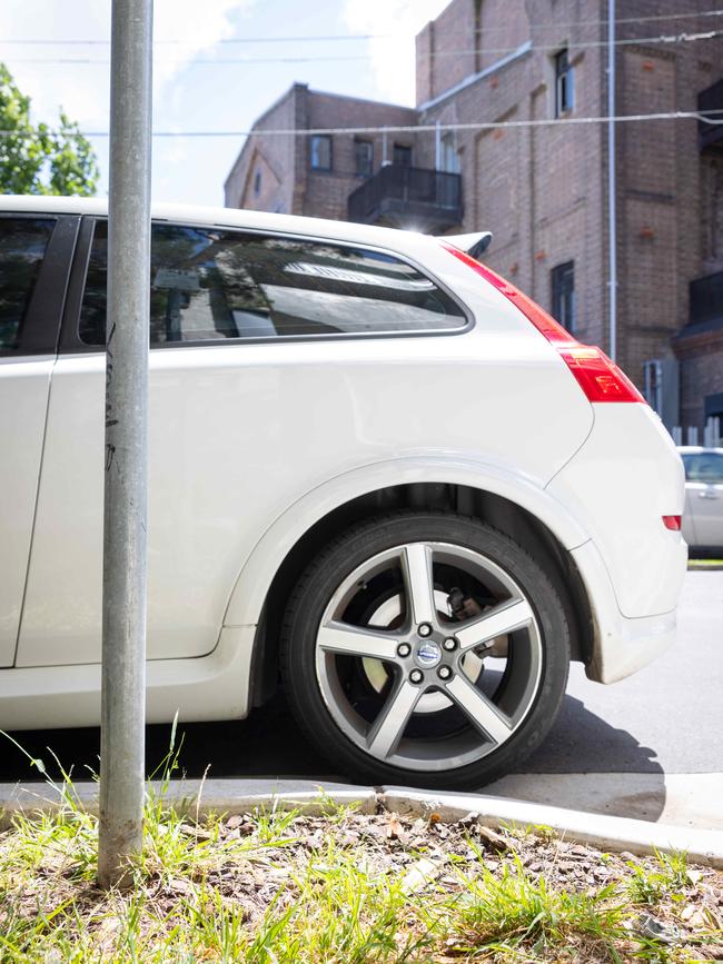 A parked car more than 1m past no-stopping zone on a turning in Newtown.