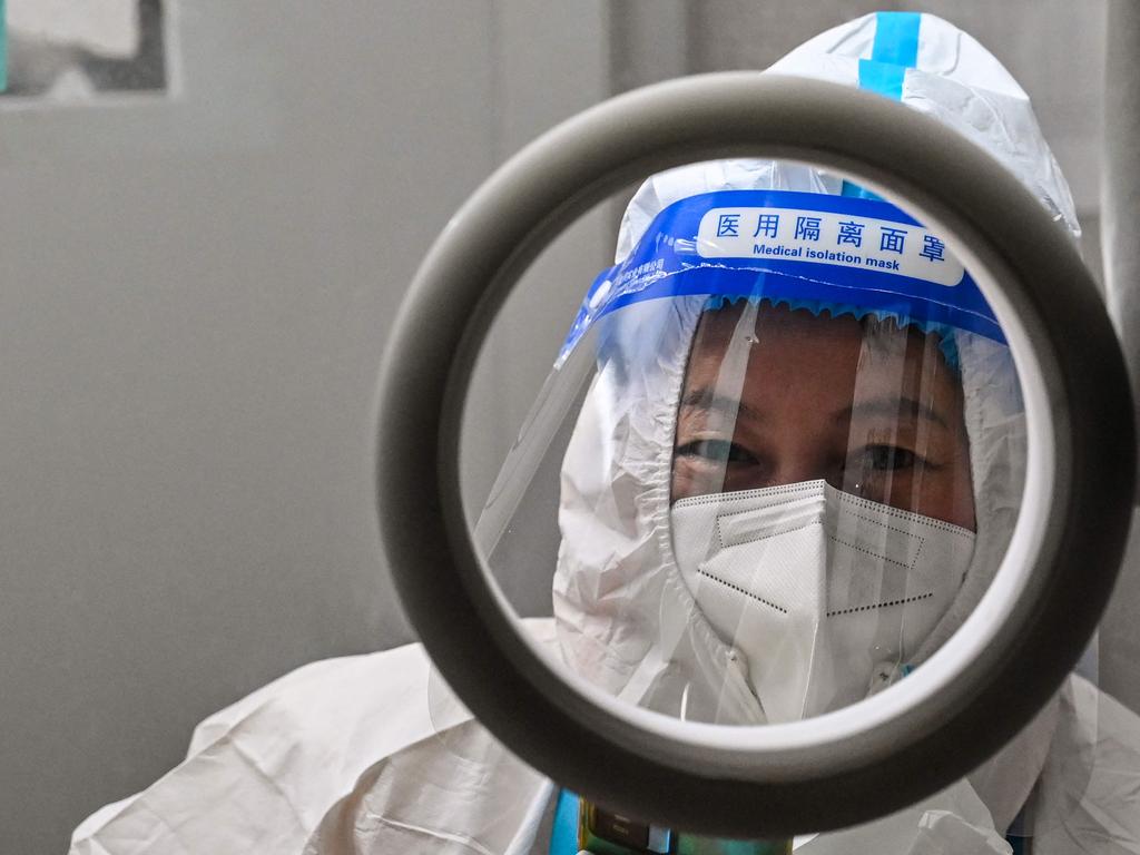 A health worker waits for people to take swab samples to test for Covid. Picture: AFP