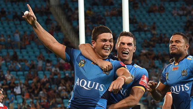 Titans player Ashley Taylor (left) reacts after scoring a try during the Round 3 NRL match between the Gold Coast Titans and the West Tigers at CBUS Stadium on the Gold Coast, Saturday, March 19, 2016. (AAP Image/Dave Hunt) NO ARCHIVING, EDITORIAL USE ONLY