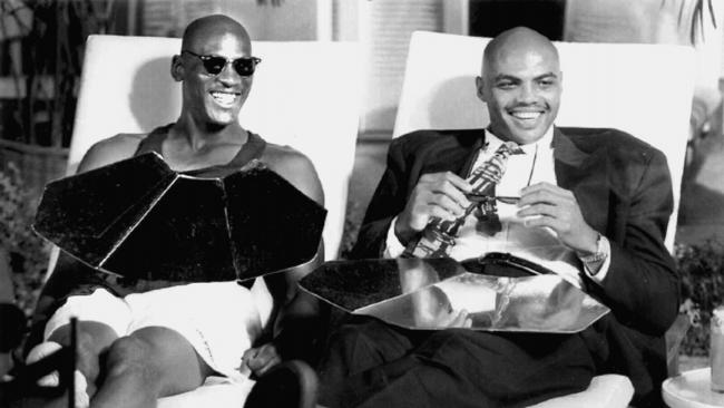 (L-R) Michael Jordan and Charles Barkley relax beside the pool between takes during filming of Nike advertisement.