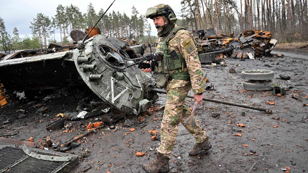 A Ukrainian serviceman walks past destroyed Russian tanks not far from the capital of Kyiv. Picture: Sergei Supinsky/AFP