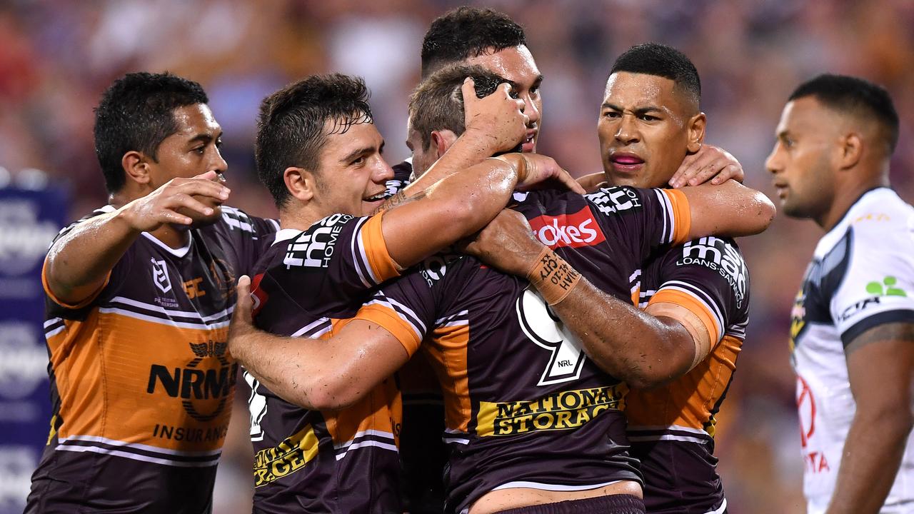 Andrew McCullough is congratulated by Broncos teammates after scoring a try against the Cowboys.