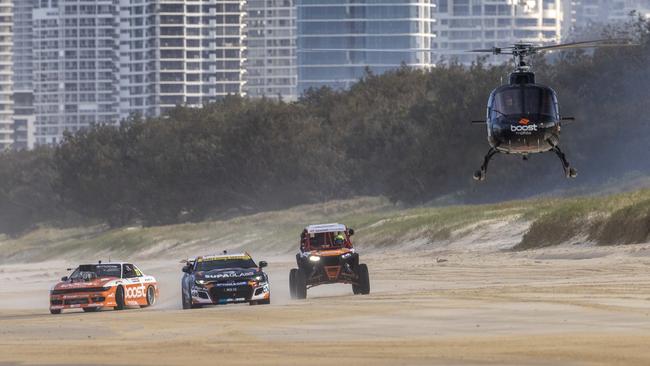 Supercars driver Cameron Hill, the Boost drift car, Buggy, Chopper, and Stunt plain as they raced along Main Beach today ahead of this weekend’s Boost Mobile GC 500, Event 11 of the Repco Supercars Championship, Surfers Paradise, Gold Coast, Queensland, Australia.