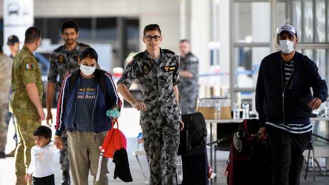 Australian residents returning from India are helped by members of the Royal Australian Navy, as they are ushered towards waiting buses for the beginning of their 14-day imposed quarantine. Picture; AAP.