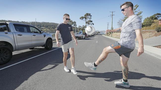 Justin Hudson and Matthew Garth entertain themselves with street soccer while they wait in line for the Bruny Island ferry. Picture: PATRICK GEE