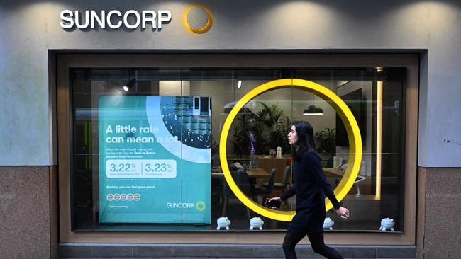 A pedestrian walks past a Suncorp Bank branch, as ANZ pushes ahead with one of the biggest takeovers in the sector for more than a decade. Picture: AFP