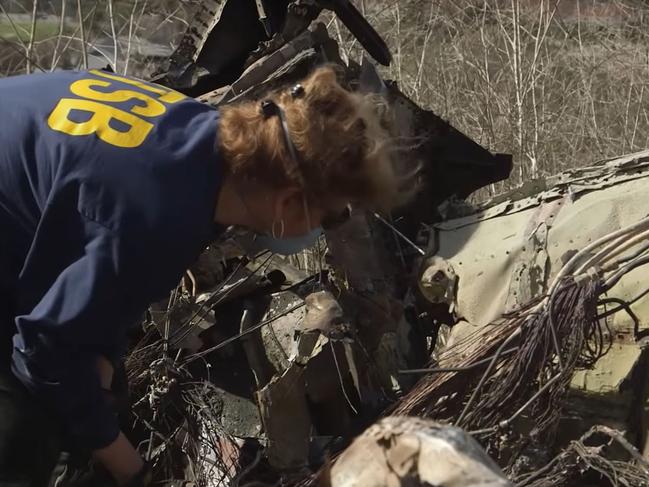 An NTSB official inspects the remains of a helicopter which crashed, killing retired NBA star Kobe Bryant, his daughter, Gianna, and seven others. Picture: AFP