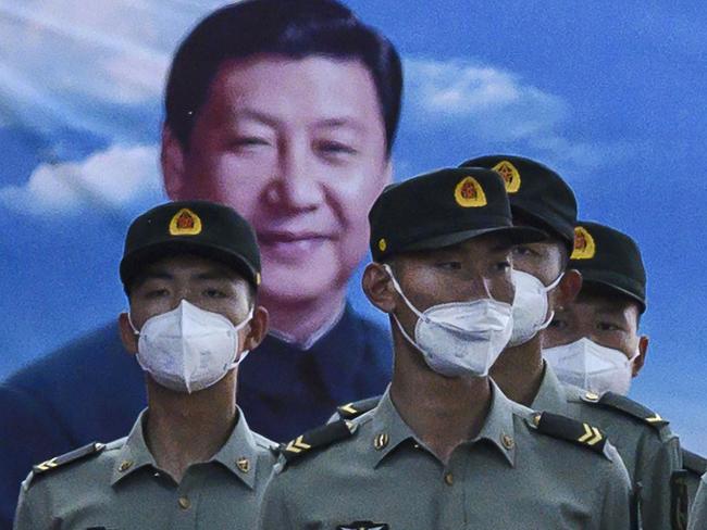 BEIJING, CHINA - MAY 20: Soldiers of the People's Liberation Army's Honour Guard Battalion wear protective masks as they stand at attention in front of photo of China's president Xi Jinping at their barracks outside the Forbidden City, near Tiananmen Square, on May 20, 2020 in Beijing, China. China's government will open its annual weeklong meetings known as the 'two sessions' at the Great Hall of the People on May 21st. They were delayed in March due to the COVID-19 pandemic. After decades of growth, officials recently said China's economy had shrunk in the latest quarter due to the impact of the coronavirus epidemic. The slump in the worlds second largest economy is regarded as a sign of difficult times ahead for the global economy. While industrial sectors in China are showing signs of reviving production, a majority of private companies are operating at only 50% capacity, according to analysts. With the pandemic hitting hard across the world, officially the number of coronavirus cases in China is dwindling, ever since the government imposed sweeping measures to keep the disease from spreading. Officials believe the worst appears to be over in China, though there are concerns of another wave of infections as the government attempts to reboot the worlds second largest economy. Since January, China has recorded more than 82,000 cases of COVID-19 and at least 4000 deaths, mostly in and around the city of Wuhan, in central Hubei province, where the outbreak first started. (Photo by Kevin Frayer/Getty Images)