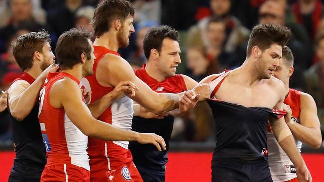 Swans players wrestle with Tomas Bugg of the Demons.