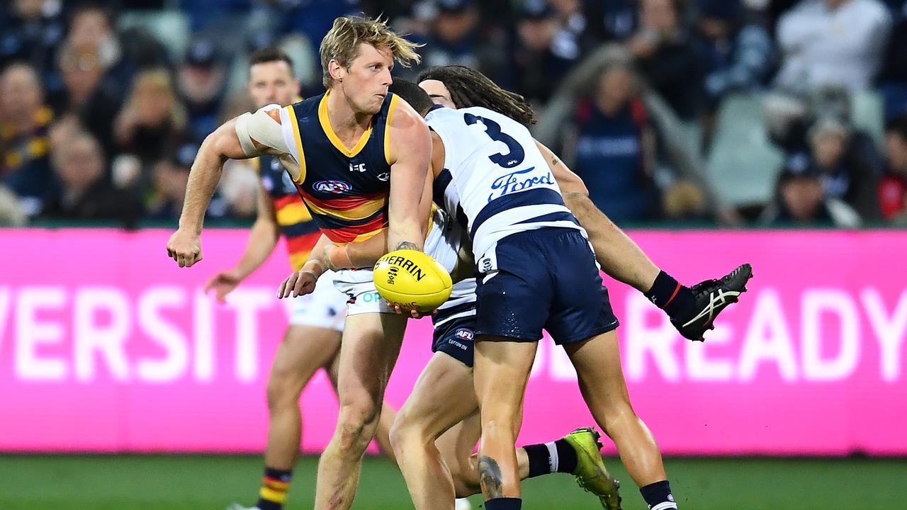 Rory Sloane of the Crows handballs while being tackled by Brandan Parfitt of the Cats. Picture: Getty Images