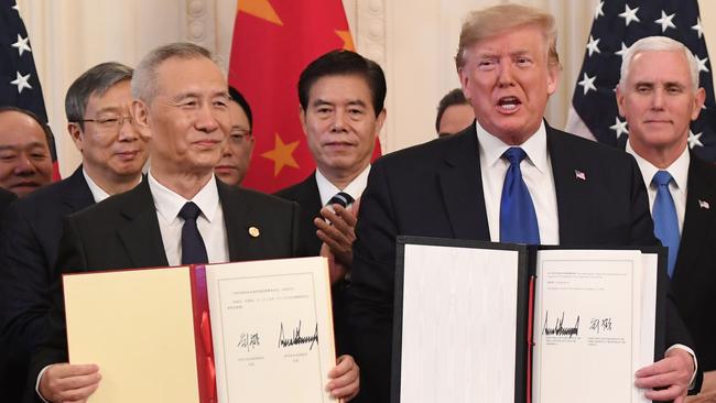 Chinese Vice Premier Liu He and US President Donald Trump display the signed trade agreement between the US and China. Picture: AFP