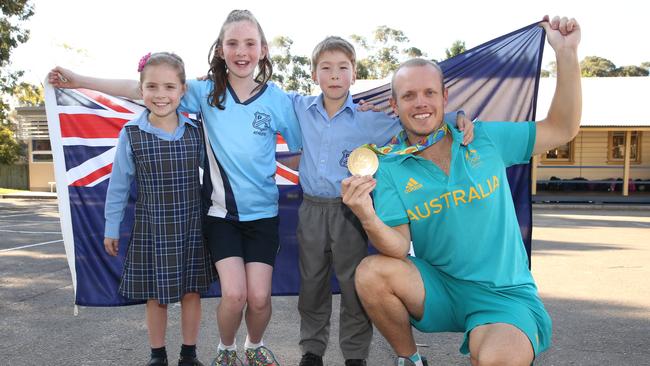 North Rocks Public School students Amelia Palermo (year 2), Broadie Wilkinson (year 5) and Madden Mah Chut (kindy) with Olympic gold medallist Tom Burton. Pictures: David Swift