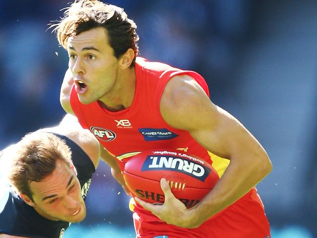 MELBOURNE, AUSTRALIA - MARCH 31:  Lachie Weller of the Suns runs with the ball past David Cuningham of the Blues  during the round two AFL match between the Carlton Blues and the Gold Coast Suns at Etihad Stadium on March 31, 2018 in Melbourne, Australia.  (Photo by Michael Dodge/Getty Images)