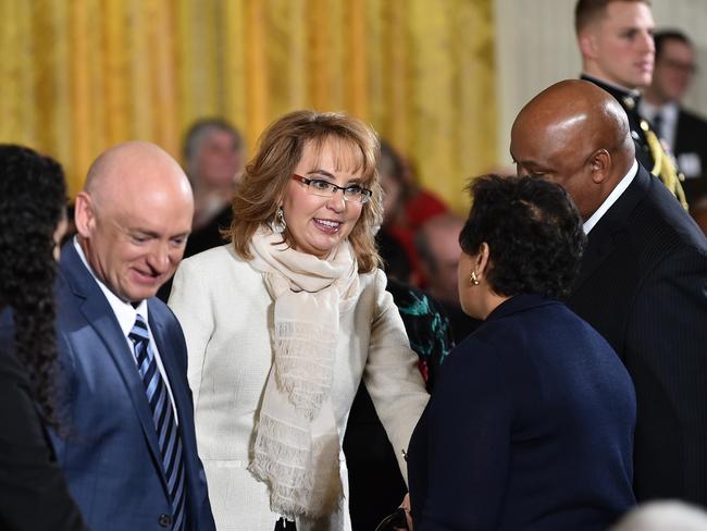 Support ... former congresswoman and gun violence victim Gabrielle Giffords (centre) and her husband astronaut Mark Kelly (left) at the White House to hear Barack Obama’s address. Picture: AFP/Mandel Ngan