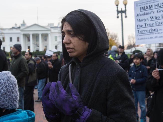 Need for registration: A Shiite Muslim woman prays during a demonstration against terrorism outside the White House in Washington on December 6. AFP PHOTO/NICHOLAS KAMM