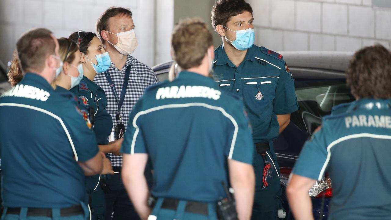 Paramedics prepare to transport quarantine guests. Photo: Tara Croser.