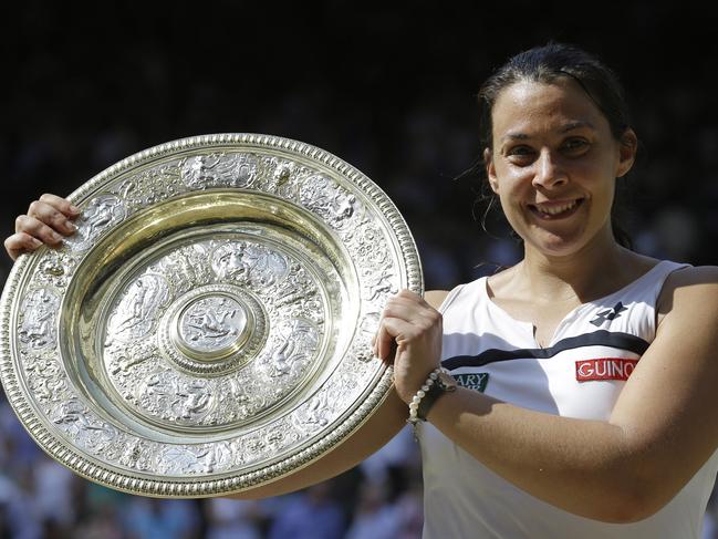 FILE - In this July 6, 2013, file photo Marion Bartoli, of France, smiles as she holds the trophy after winning the women's singles final match against Sabine Lisicki of Germany at the All England Lawn Tennis Championships in Wimbledon, London. Bartoli says she is coming out of retirement and returning to the tennis tour next season. The 33-year-old Frenchwoman made the announcement via a Twitter post on Tuesday, Dec. 19, 2017. (AP Photo/Anja Niedringhaus, File)