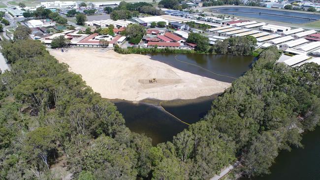 Workers move earth at Black Swan Lake at Bundall, which has almost been filled in. Picture Glenn Hampson