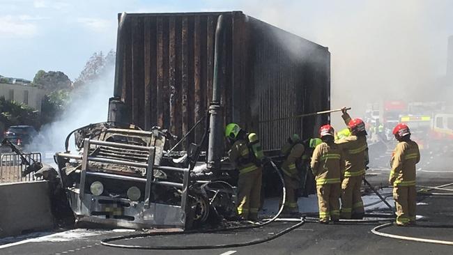 Firefighters continue to douse down the truck after it burst into flames on the M5. Picture: Live traffic Sydney