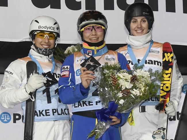 Xu Mengtao, center, of China, celebrates her win with Lydia Lassila, left, who places second, and Laura Peel, who was third, in the women's World Cup freestyle skiing aerials in Lake Placid.