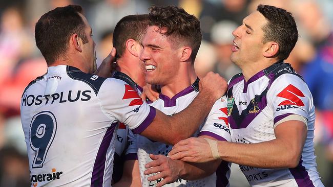 Brodie Croft celebrates a try with his teammates.