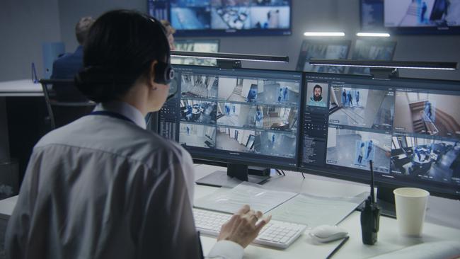 A security officer in headset controls CCTV cameras with AI facial recognition. Picture: supplied