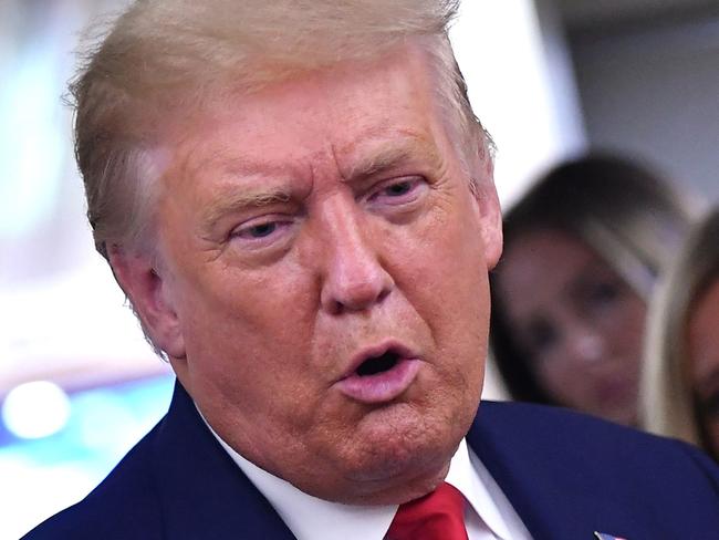 US President Donald Trump, flanked by White House Press Secretary Kayleigh McEnany, speaks to reporters onboard Air Force One after a campaign rally in Mosinee, Wisconsin on September 17, 2020. (Photo by MANDEL NGAN / AFP)