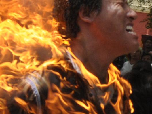 NEW DELHI, INDIA - MARCH 26: A Tibetan man (Jhampel Yetshi) screams as he runs engulfed in flames after self-immolating at a protest in New Delhi, India, ahead of Chinese President Hu Jintao's visit to the country Monday, March 26, 2012. The Tibetan activist lit himself on fire at the gathering and was rushed to hospital with unknown injuries, reports said. (Photo by K Asif/India Today Group/Getty Images)