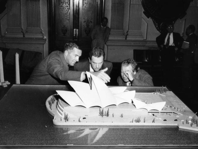 Danish architect Jorn Utzon (L) shows his original, freefrom roof design for an Opera house in Sydney at Sydney Town Hall in August 1957.