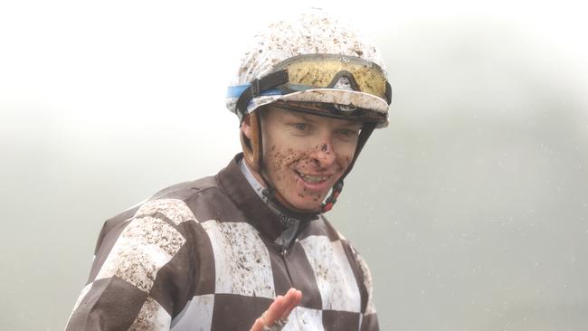 A muddied Michael Dee returns to scale before the rest of the Randwick program was abandoned because of the deteriorating conditions. Picture: Jason McCawley/Getty Images